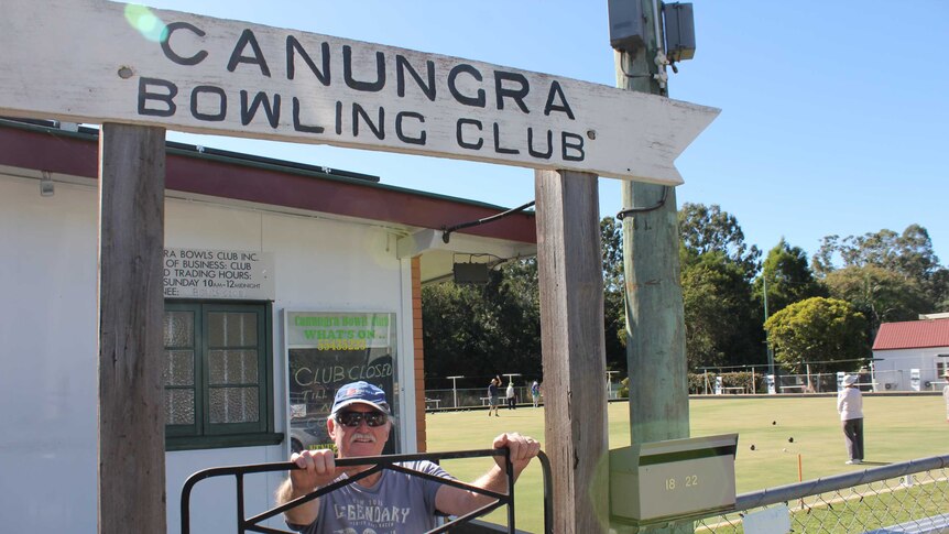 Brian Laurence Greens Director Canungra Bowls Club standing underneath official sign and gate