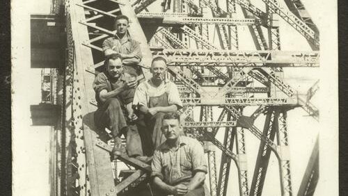 Bridge fitters posing on the framework of the Story Bridge