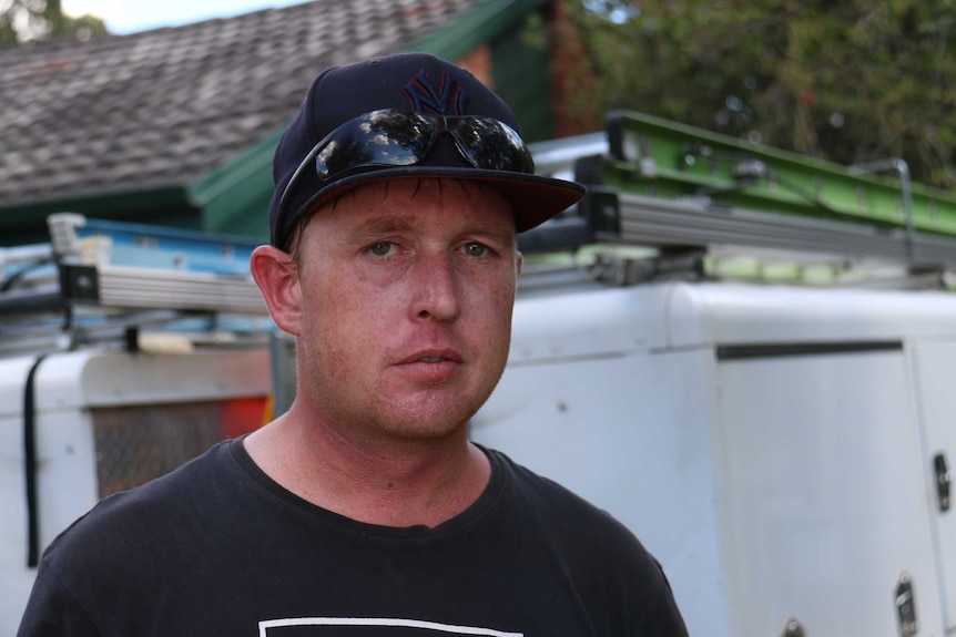 Robert Mutch wears a black T-shirt and cap