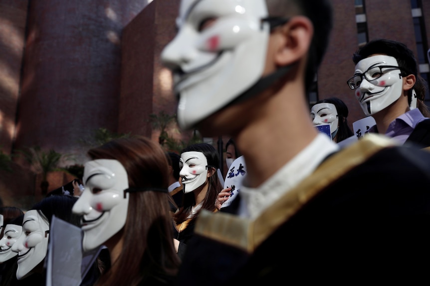 Students from Hong Kong Polytechnic University wear Guy Fawkes masks to support anti-government prote