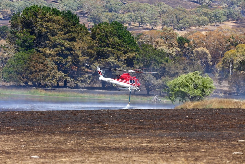 A helicopter fights the Tarago fire from above.