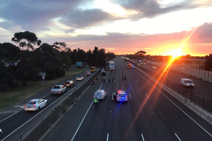 Police vehicles close a wide freeway.