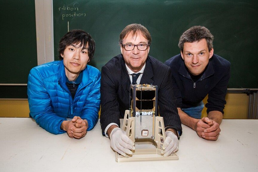 Builders of Sydney University's CubeSat with the craft.