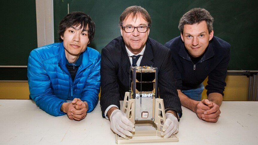 Builders of Sydney University's CubeSat with the craft.