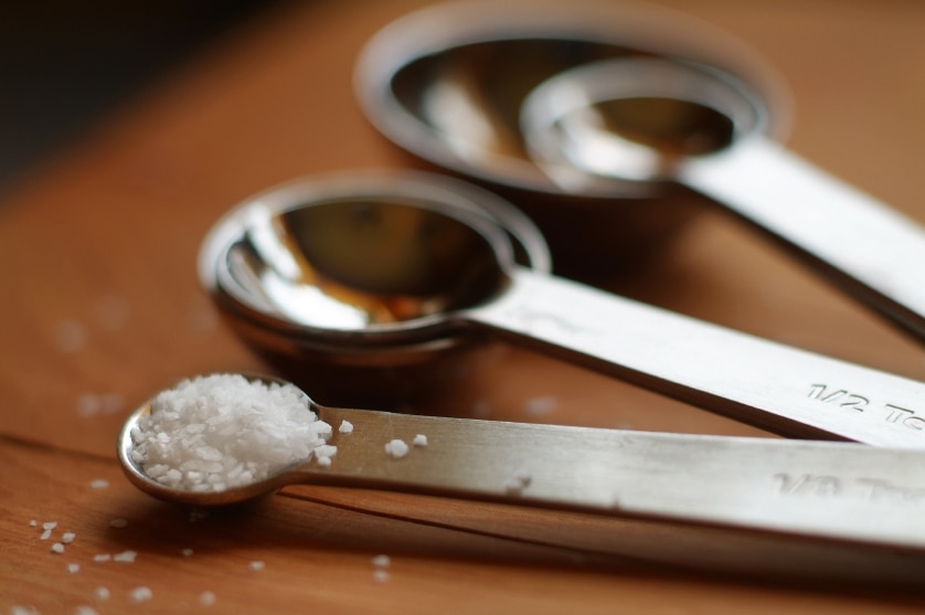 A set of measuring spoons, one with salt in it.