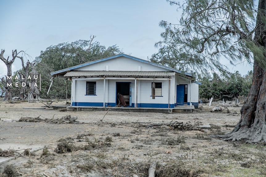 Broken trees surround a lone standing church on an island of Tonga post tsunami.