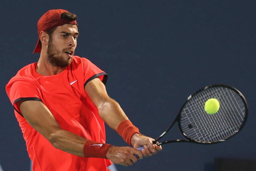 Karen Khachanov hits a backhand return.