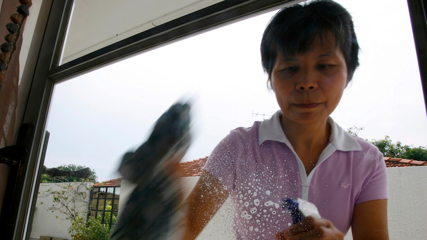 Maid in Singapore cleaning windows