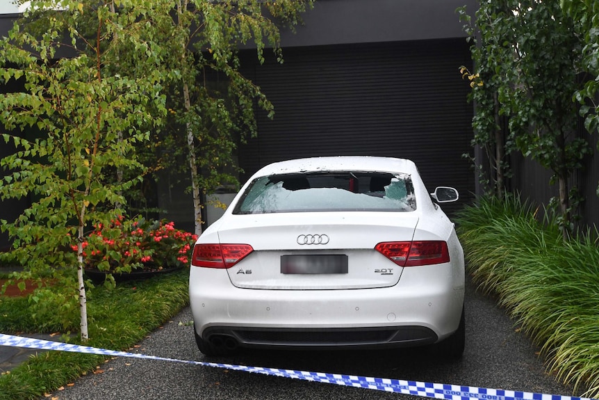 The back window of an Audi car was shot out in the driveway of a house.