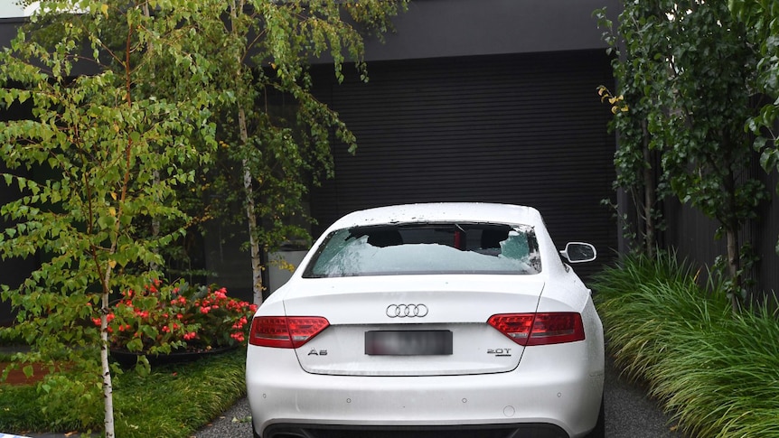 The back window of an Audi car was shot out in the driveway of a house.