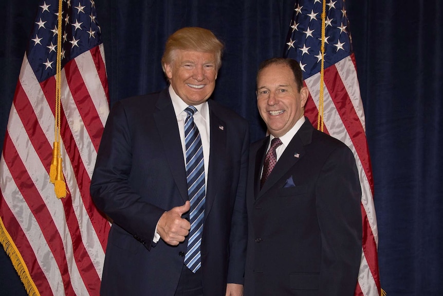 Donald Trump and Charles Herbster stand between two American flags.