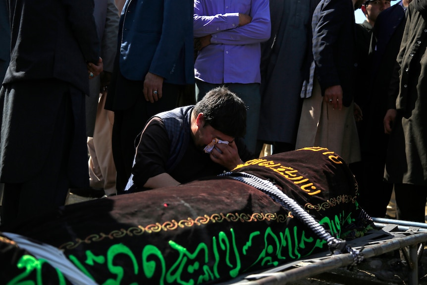 A man cries over the body of a victim of the deadly bombings