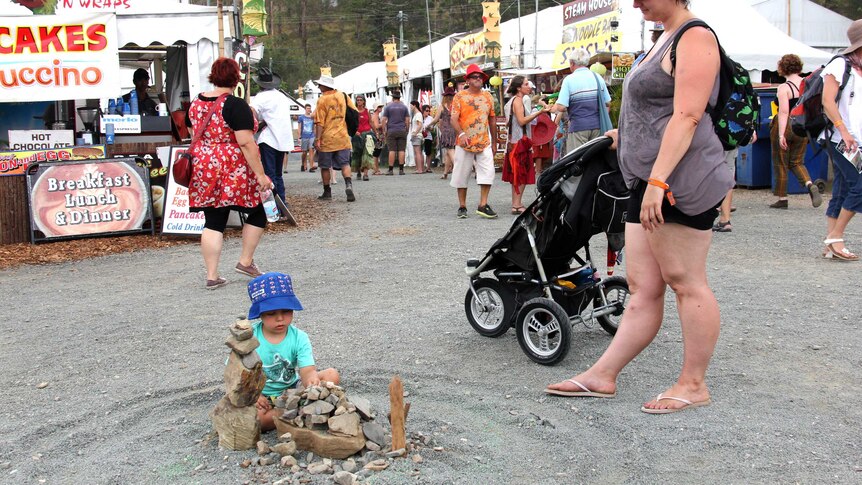 Toddler makes a stone sculpture at the Woodford Folk Festival.
