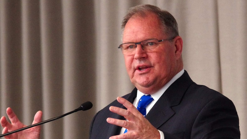 Robert Doyle speaking at a lectern. He is using his hands as he speaks