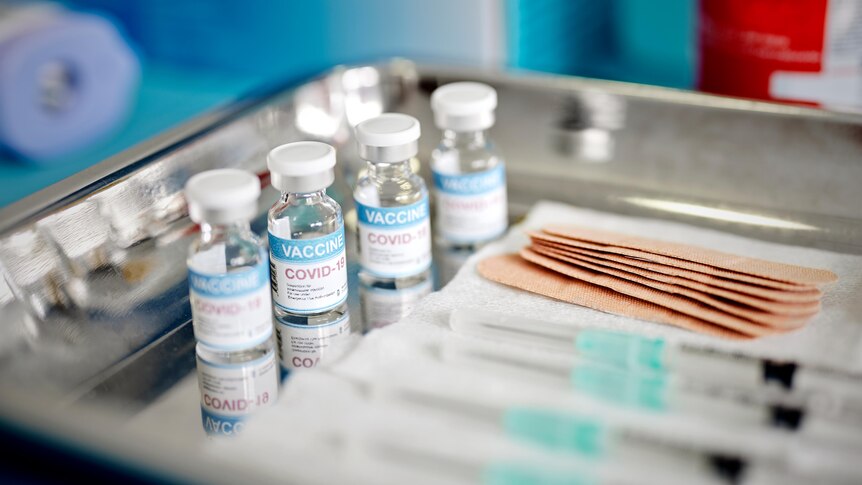 Close up of vials and syringes with Covid-19 vaccine are displayed on a tray during vaccination.