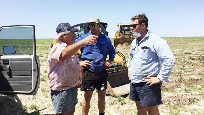 Grazier David Batt speaks to brothers, Ash and Matt Travers at his property near Winton.