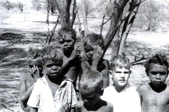 old black and white image of Jol surrounded by his aboriginal friends at Yuendumu