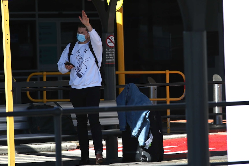 A traveller hails a taxi at Perth Airport after getting off a flight from Melbourne.