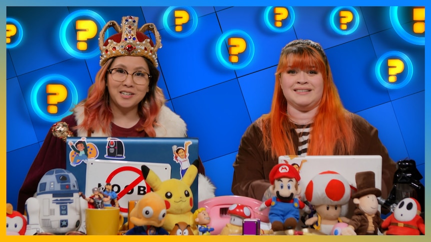 Rad wearing a crown and and cap and Gem sitting at the Ask SP desk.