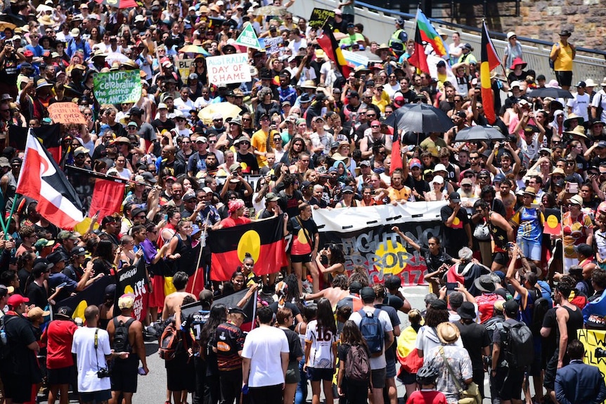 A large crowd protest on a Brisbane bridge