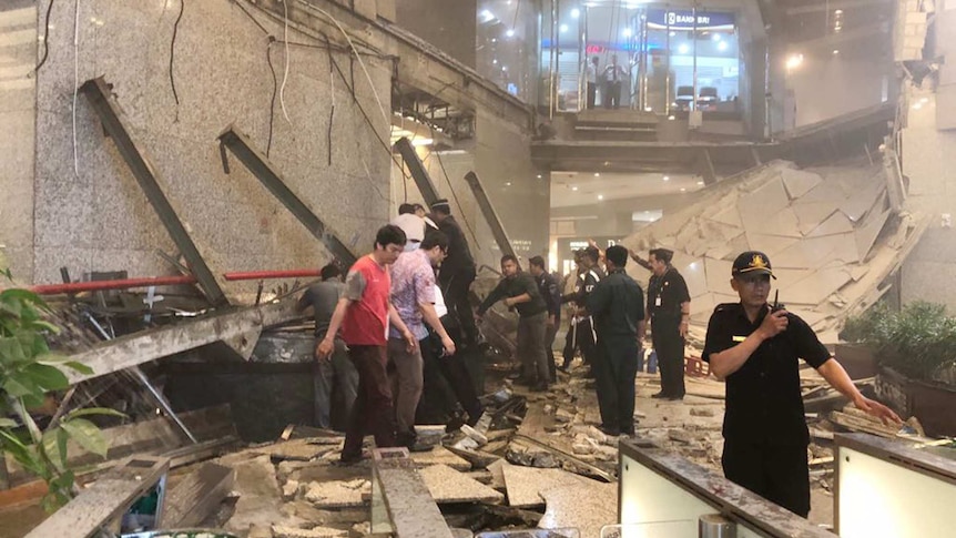 Security stands guard in front of a collapsed floor.