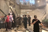 Security stands guard in front of a collapsed floor.