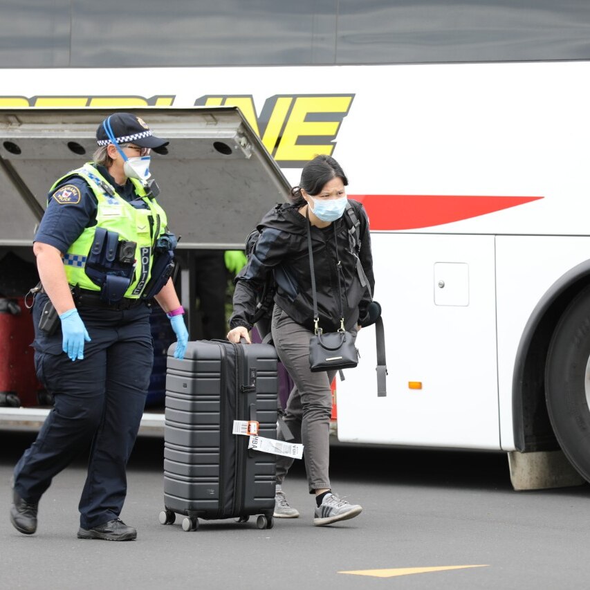 A traveller is escorted from a bus in Hobart to a hotel