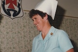 Graduation ceremony from 1985, with a nurse dressed in blue uniform and peaked cap accepting her degree.