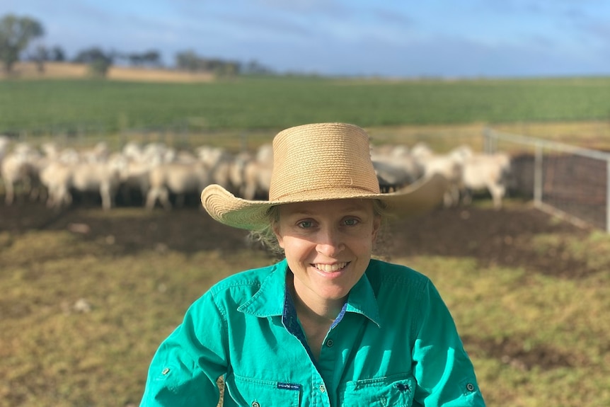 A lady in a green shirt and straw hat.