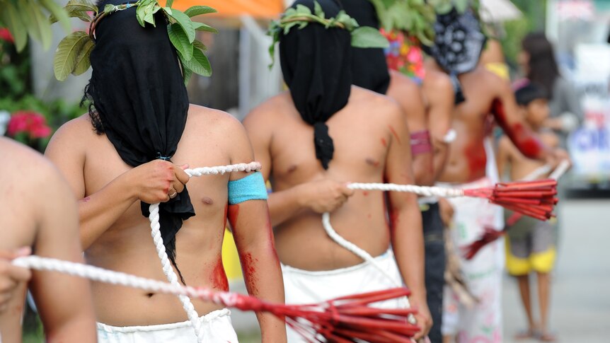 Penitents perform self-flagellation as they walk through the streets as part of the re-enactment of the crucifixion