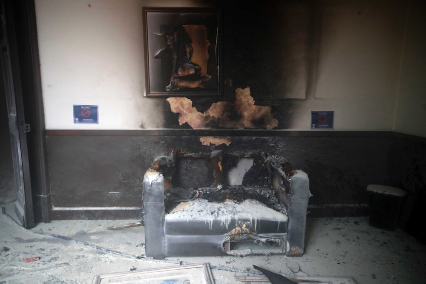 A couch and artwork destroyed by fire are seen inside the Guatemalan Congress building