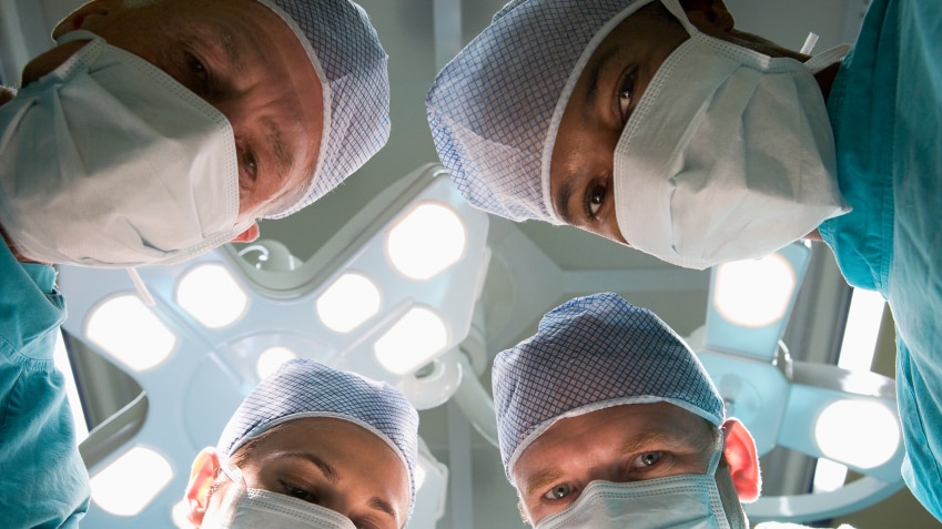 Four surgeons in an operating theater.