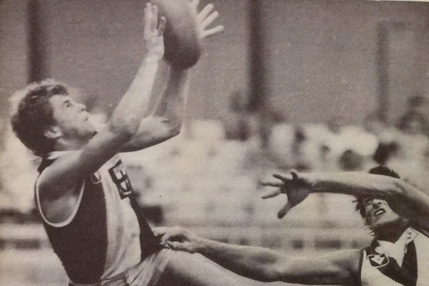 A VFL player leaps for a mark in a game at the SCG.