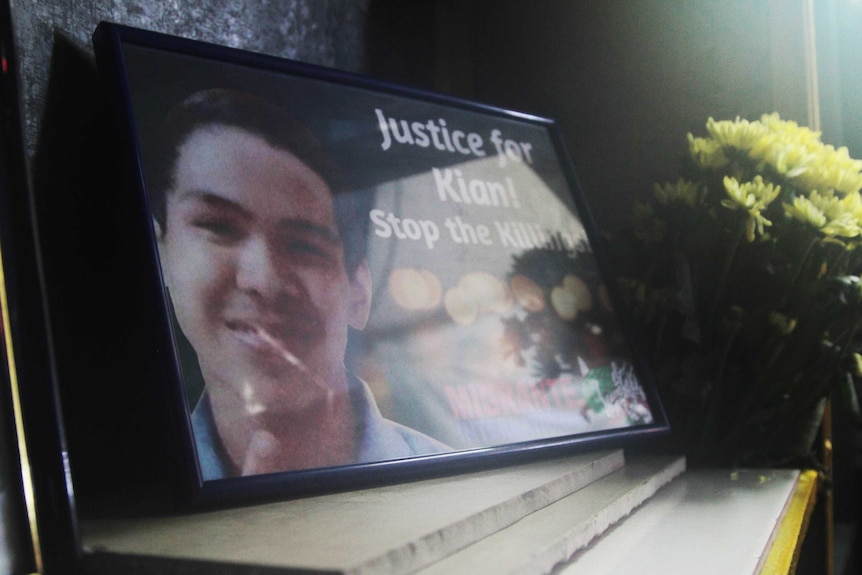 A photo of Kian Delos Santos, with the words "Justice for Kian, stop the killing" placed near his coffin.