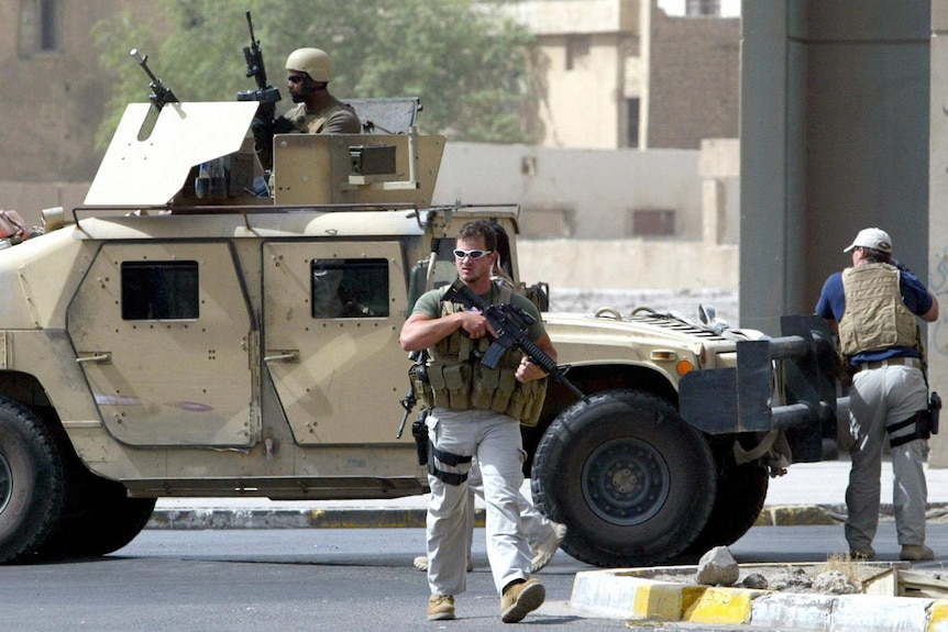 Members of the Blackwater security company with weapons and armoured car in Baghdad