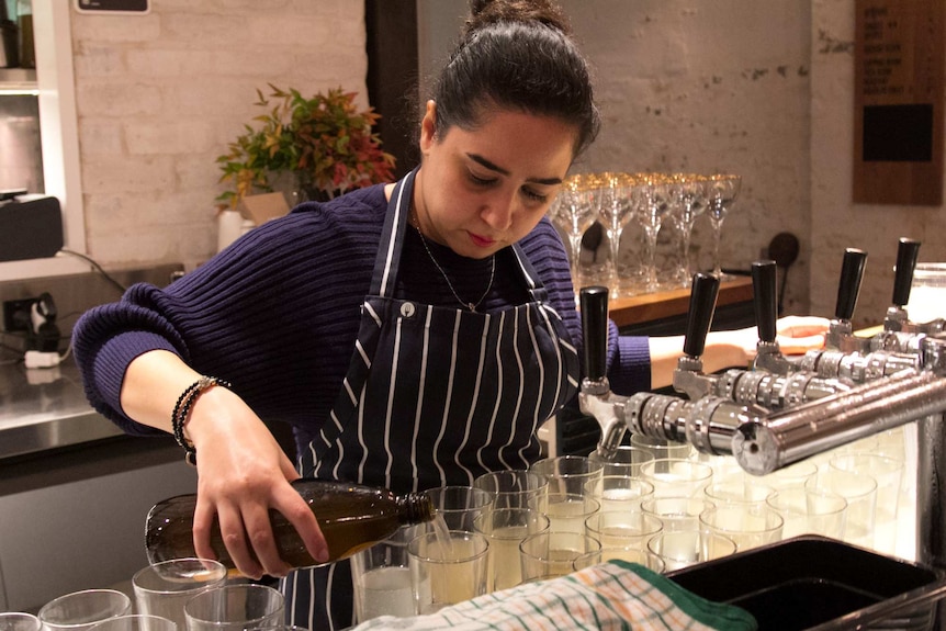 A woman prepares cocktail drinks