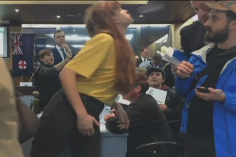 A woman appears to towards a man in a crowded area.