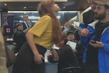 A woman appears to towards a man in a crowded area.