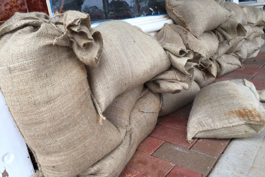 A stacked line of sandbags along a wall.