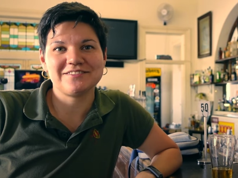 A woman with brown hair and a green shirt in a country pub.