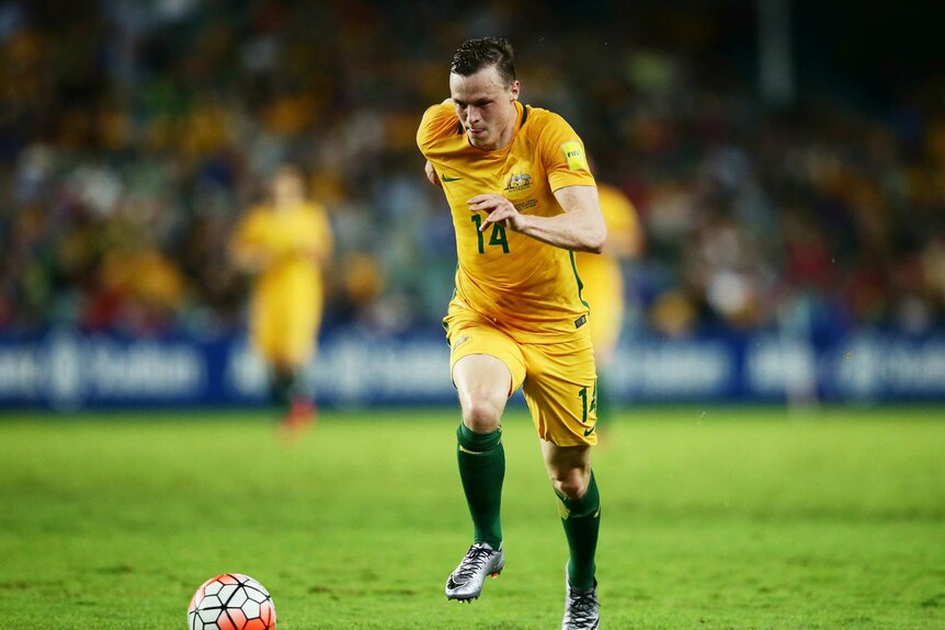 Brad Smith of the Socceroos controls the ball