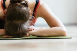 Close up shot of a woman on floor stretching her leg.