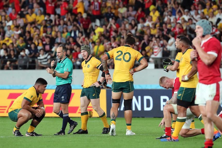 Wallabies players look dejected as the referee blows his whistle to end a loss to Wales.