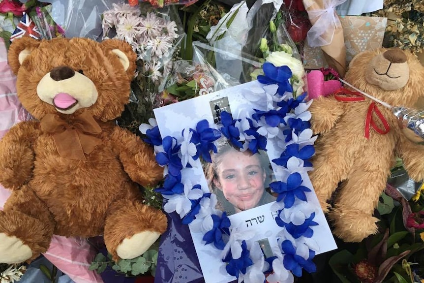 A photograph of Bourke St victim Thalia Hakin is surrounded by flowers and teddy bears.