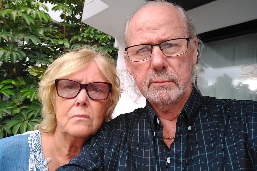 An elderly man and a woman take a photo together