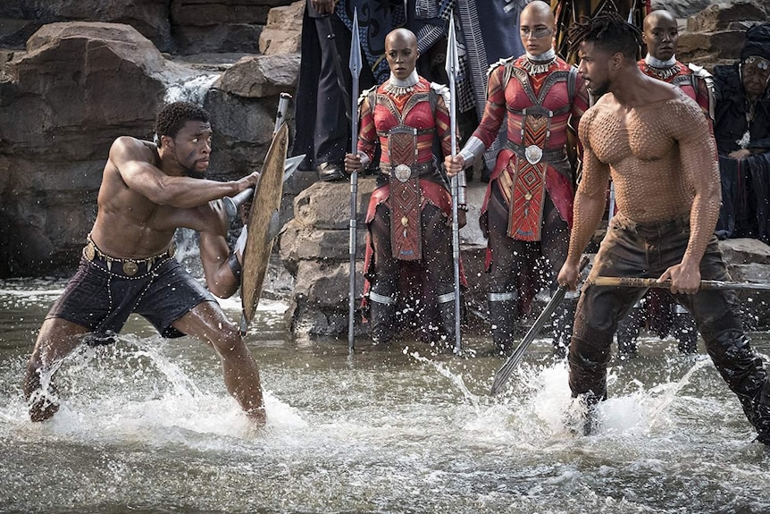 Still image of Chadwick Boseman and Michael B. Jordan in 2018 film Black Panther engaging in combat.