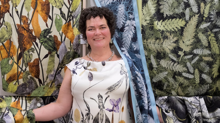 Fabric designer Deborah Wace stands amongst some of her fabrics based on botanical designs.