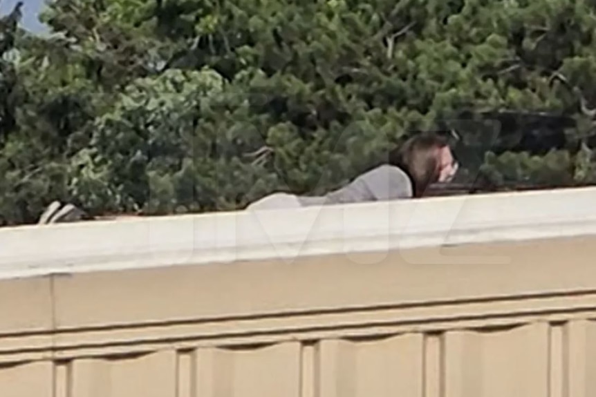 a man with long hair lying down on a rooftop