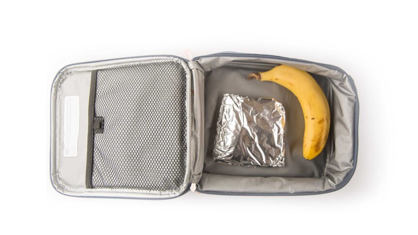 A cheese and tuna sandwich wrapped in foil and a banana in a grey cooler bag.