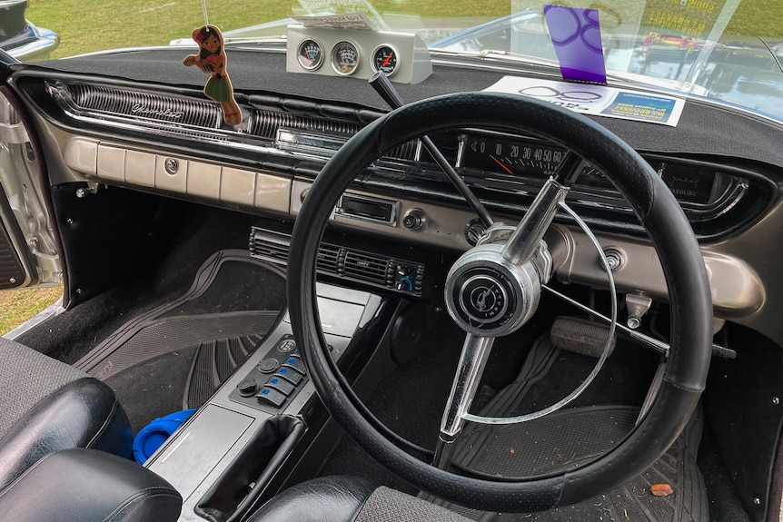 Inside a classic car with side-gears and a steering wheel. 